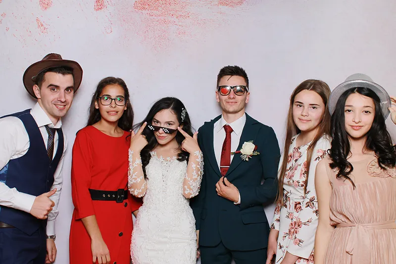 Nuntași eleganți pozând cu ochelari de soare haioși la cabina foto